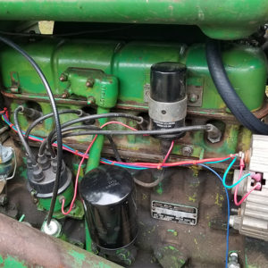 Looking at components of the motor of a green tractor